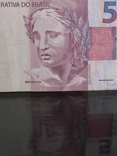 在有倒影的玻璃桌上处理巴西钞票的方法 — 图库照片