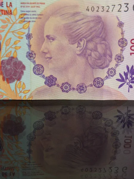 在有倒影的玻璃桌上处理阿根丁钞票的方法 — 图库照片