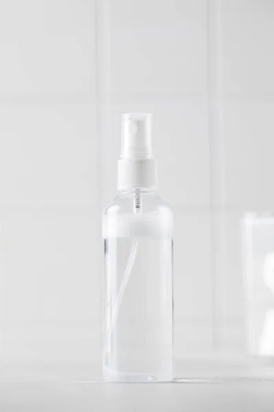 Tonic or facial lotion in a clear plastic bottle on a white background. Daily skin care. Copy space.