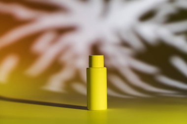 Boş plastik şişe doğal kozmetik ve gölge desenli sarı ışık