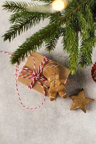 Cadeaus en peperkoek man liggen op grijze achtergrond met kerstboom takken — Stockfoto