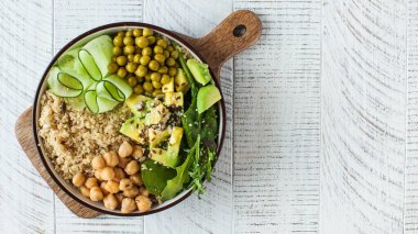 Buddha kâsesinden sağlıklı sebze tabağı, kinoa, avokado ve nohut. Boşluğu kopyala.