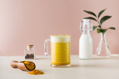 Daha iyi uyumak için ay sütü. Pembe arka planda zerdeçal ile altın latte. Ayurvedic içki. Boşluğu kopyala.
