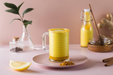 Pembe arka planda Latte zerdeçal. Daha iyi uyumak için ay sütü. Boşluğu kopyala.