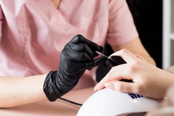 Manicure w salonie piękności. Manikiurzystka maluje paznokieć lakierem. — Zdjęcie stockowe