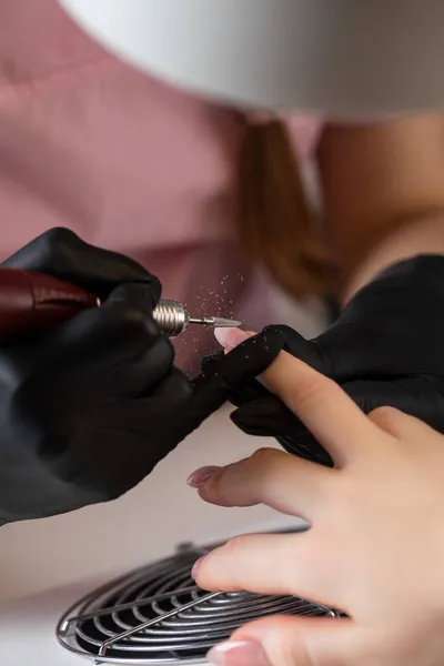 Een manicure verwijdert gellak van nagels met behulp van een freesmes. Hardware manicure close-up. Coating schellak op nagels — Stockfoto