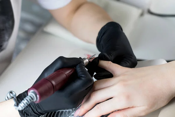 Een manicure verwijdert gellak van nagels met behulp van een freesmes. Hardware manicure close-up. Coating schellak op nagels — Stockfoto