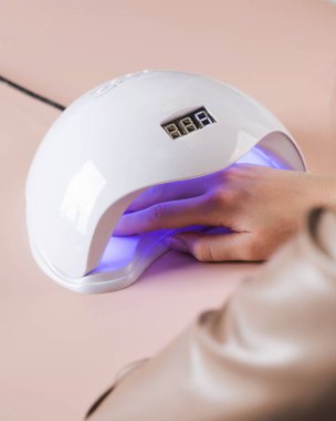  Shellac kaplamalı manikür. Ultraviyole lambada kurutma işlemi.