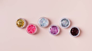 Pembe arka planda şenlikli manikür Noel partisi için parlak sim tozu.