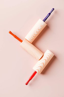 Açık pembe arka planda parlak tırnak cilası şişelerinin farklı renk fırçaları. Boşluğu kopyala.