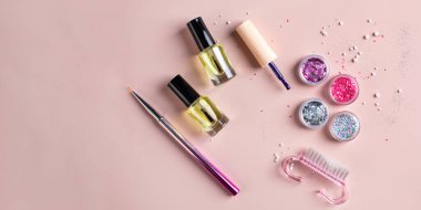 Pembe arka planda şenlikli bir manikür yapmak için bir dizi pullar, cilalar, fırçalar. Boşluğu kopyala