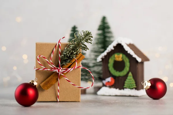 Kerstgeschenkdoos op een achtergrond van kerstboomtakken, rode kerstballen en kerstverlichting. Kopieerruimte. — Stockfoto