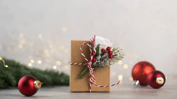 Caja de regalo de Navidad sobre un fondo de ramas de árbol de Navidad, bolas de Navidad rojas y luces de Navidad. Copiar espacio. —  Fotos de Stock