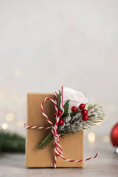 Caja de regalo de Navidad sobre un fondo de ramas de árbol de Navidad, bolas de Navidad rojas y luces de Navidad. Copiar espacio. —  Fotos de Stock