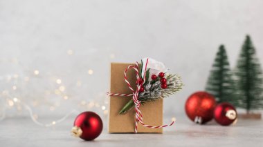  Noel ağacı dallarının, kırmızı Noel balolarının ve Noel ışıklarının arka planında Noel hediyesi kutusu. Boşluğu kopyala.