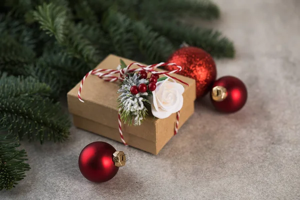 Caja de regalo de Navidad sobre un fondo de ramas de árbol de Navidad, bolas de Navidad rojas. Copiar espacio. —  Fotos de Stock