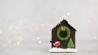 Kuş evi ve Noel ışıkları olan bir Noel kompozisyonu. Boşluğu kopyala.