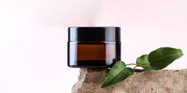 Afiş Kavanozu pembe arka planda beton plakalar üzerine doğal kozmetik ürünüyle