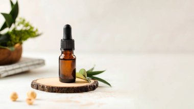  Arka planda bitkiler olan yüz bakımı için serumlu damga. Boşluğu kopyala.