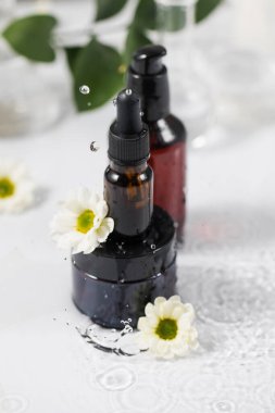 Organik kozmetik ürünleri suyun üzerinde duruyor ve etrafta su damlaları var..