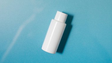  Su ve dalgalarla dolu mavi bir havuzda beyaz kozmetik şişesi. Kaplıca cilt bakımı.