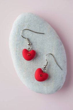 Kırmızı kalp şeklinde küpeler, kendi elleriyle polimer kilden yapılmış..