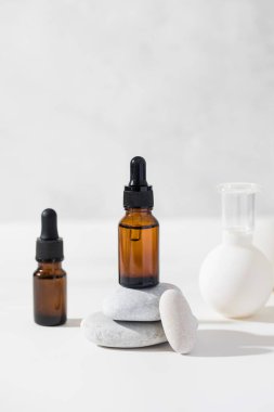 Kahverengi damlacıklar ve kozmetik ürünleri arka planda taş kaidesi ve vakum pompaları var..