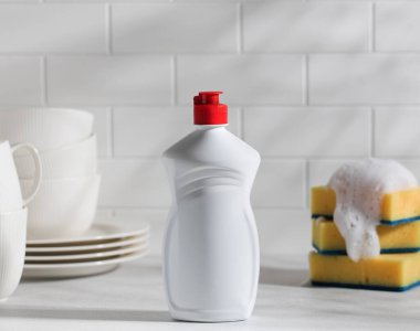 Bulaşık jeli, gölgeli beyaz plastik ve köpüklü sarı süngerler. 