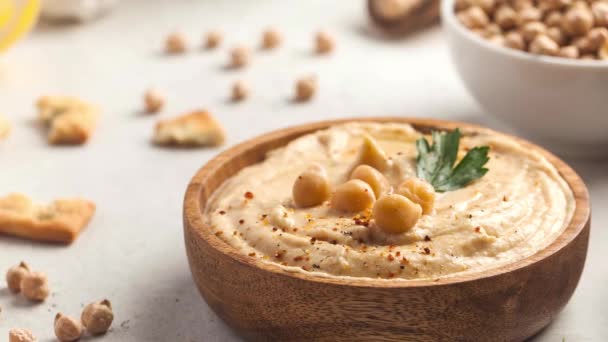Hummus em uma chapa de madeira com salsa e croutons. Pratos de grão de bico. — Vídeo de Stock