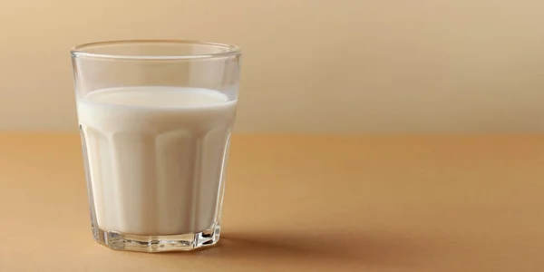 Banner. Un vaso de leche fresca sobre un fondo beige. Copiar espacio —  Fotos de Stock