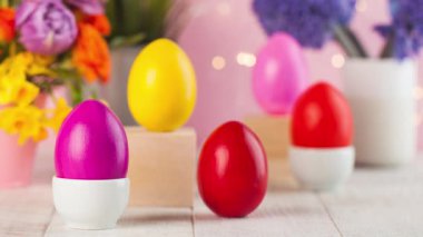 Paskalya kartı. Bir buket çiçeğin arkasında renkli Paskalya yumurtaları.