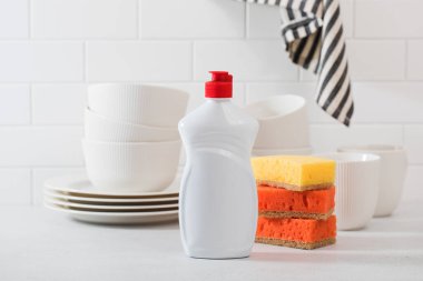Beyaz fayanslı arka planda bulaşık yıkamak için jöleli beyaz plastik şişe.. 