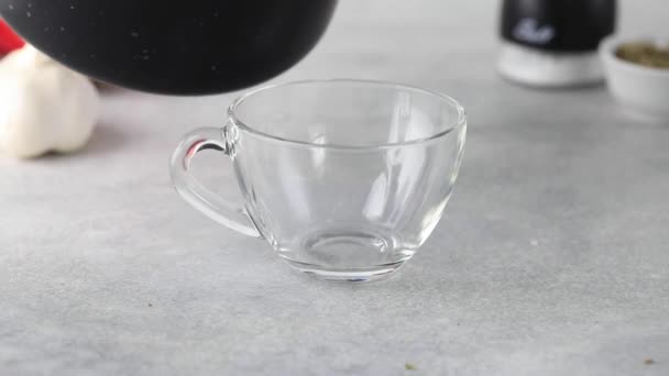 Vidéo. Bouillon d'os fait maison est versé dans une tasse transparente. — Video