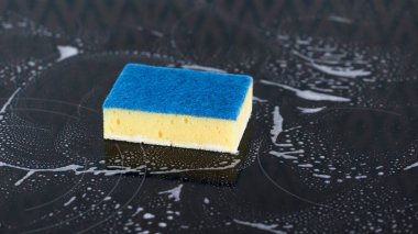 Köpüklü fırının üzerindeki sarı sünger. Genel temizlik kavramı.