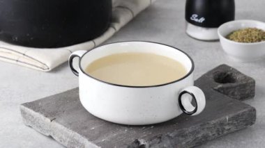 Beyaz bir kaseye bir kepçe sağlıklı ev yapımı kemik suyu dök. Sağlıklı beslenme kavramı. 