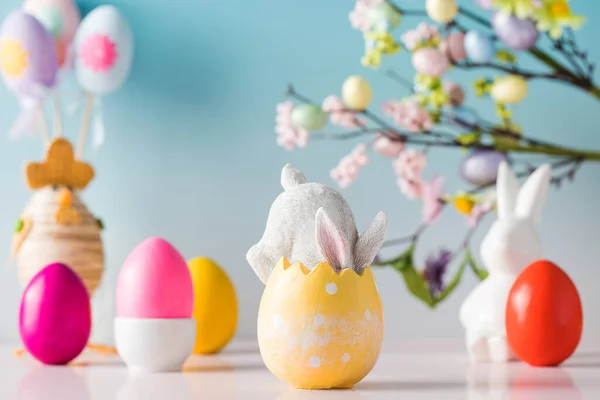 Composición festiva de Pascua con un conejo en un huevo de Pascua sobre un fondo floral — Foto de Stock