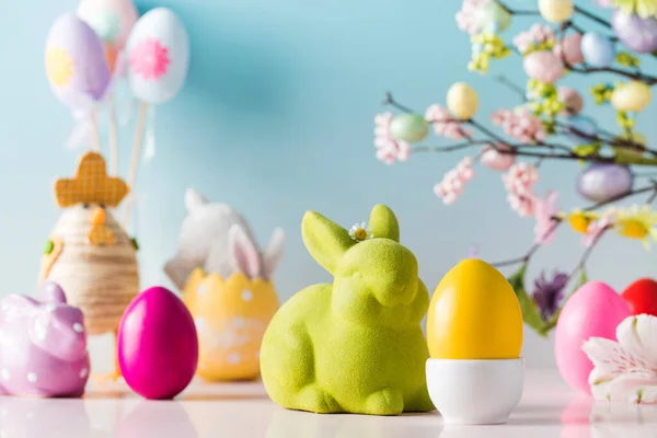 Composición festiva de Pascua con huevos de Pascua y conejos sobre un fondo azul. — Foto de Stock