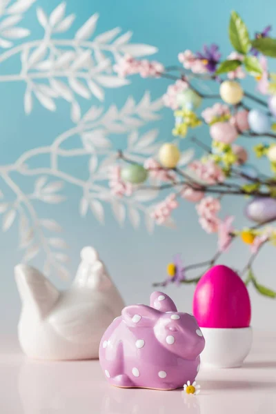 Easter card made of decorative figurines and a beautiful egg on a blue background with flowers — Stock Photo, Image
