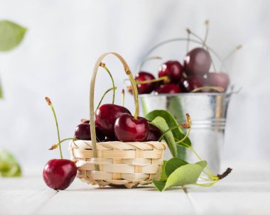 Tahta bir arka planda sepetin içinde olgun kirazlar. Boşluğu kopyala.