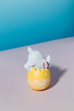 Mavi arka planda Paskalya yumurtası içinde beyaz bir tavşan. Mutlu Paskalya konsepti.