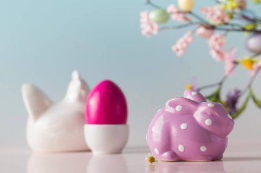 Süslü heykelciklerden yapılmış Paskalya kartı ve mavi arka planda çiçekli güzel bir yumurta.