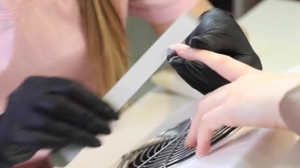 A manicurist files nails with a metal file. Manicure process in a beauty salon. — Stock Video