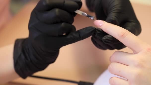 美容院的修指甲过程。美甲师把钉子漆成清漆. — 图库视频影像