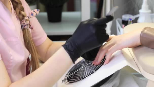 En manikyrist filar naglar med en metallfil. Manikyr process i en skönhetssalong. — Stockvideo