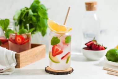 Hafif arka planda çilek, limon ve nane aromalı ferahlatıcı bir yaz içeceği. Çilekli limonata.