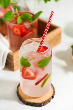 Hafif arka planda çilek, limon ve nane aromalı ferahlatıcı bir yaz içeceği. Çilekli limonata.