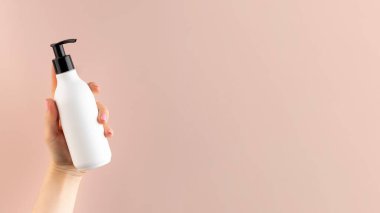 Açık pembe arka planda bir kadının elinde kozmetik ürünü olan beyaz bir şeker kutusunun maketi..