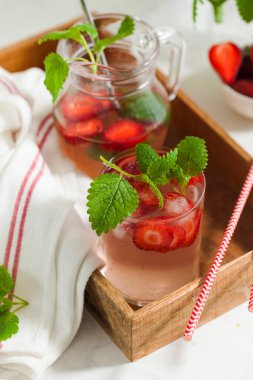 Sürahi ve bardakta ev yapımı taze çilekli limonata.