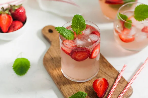Homemade refreshing strawberry lemonade in glasses and jug with fresh strawberries and mint leaves. Summer drink — Stock Photo, Image