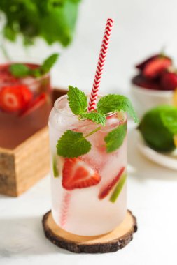 Hafif arka planda çilek, limon ve nane aromalı ferahlatıcı bir yaz içeceği. Çilekli limonata.